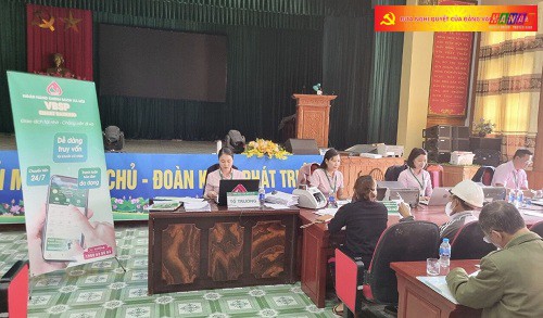 Cán bộ NHCSXH huyện Bình Lục tuyên truyền hướng dẫn khách hàng cài đặt ứng dụng VBSP Smart banking . Ảnh NHCSXH huyện Bình Lục