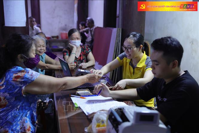 Người dân đến nhận được lĩnh tiền tháng 8 và truy lĩnh số tiền chênh lệch tăng thêm của tháng 7/2023. Ảnh: Hoàng Hiếu/TTXVN